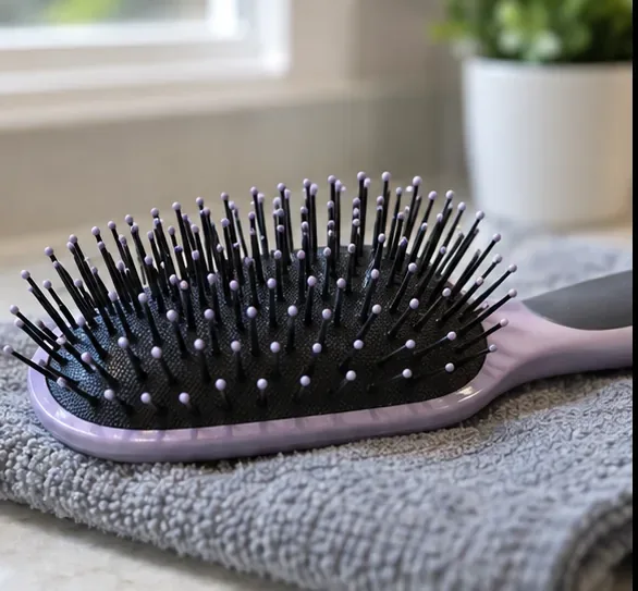 Clean paddle hairbrush resting on a folded towel to air-dry