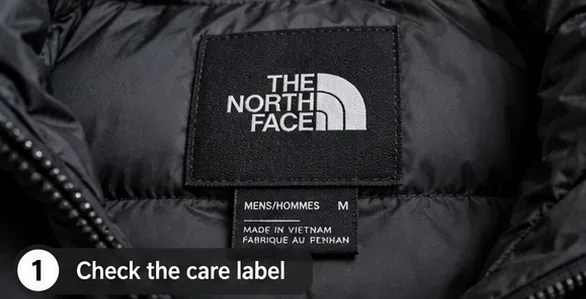 Krupni plan unutarnjeg dijela etikete crne puhaste jakne The North Face