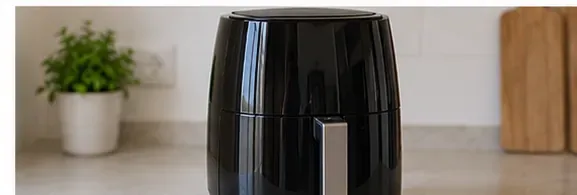 Rengjort svart airfryer står montert på en ren kjøkkenbenk